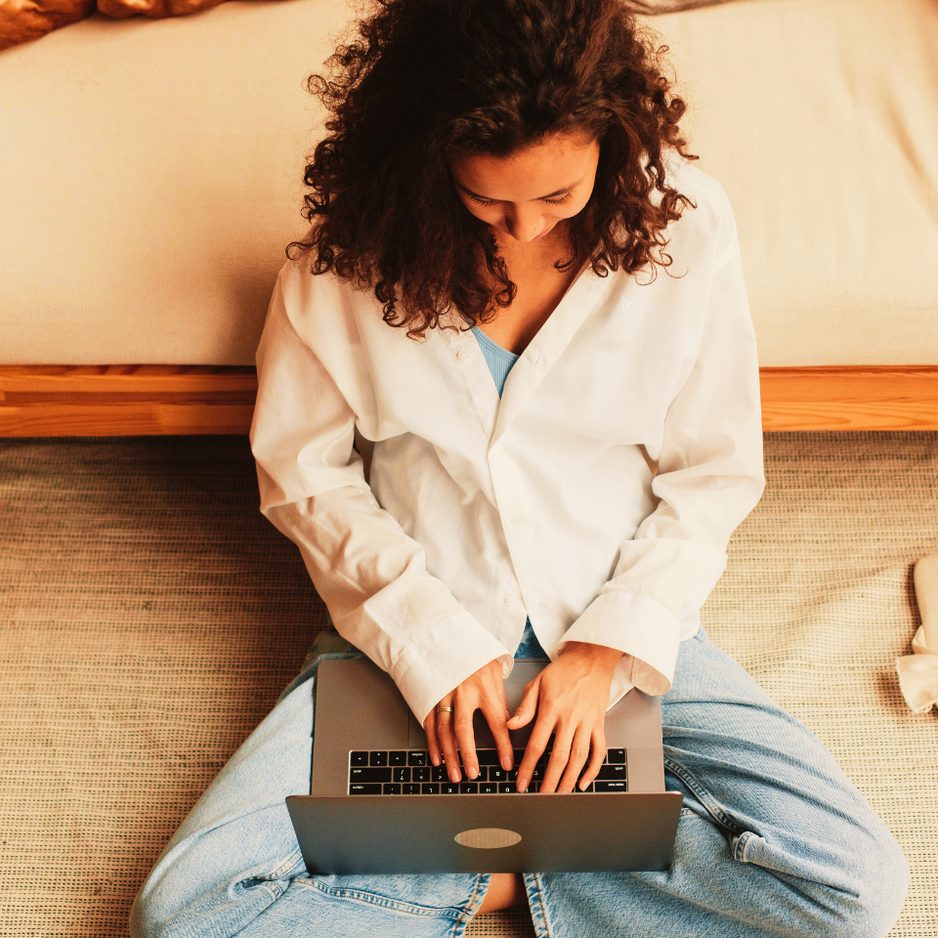 Vrouw met laptop op de vloer