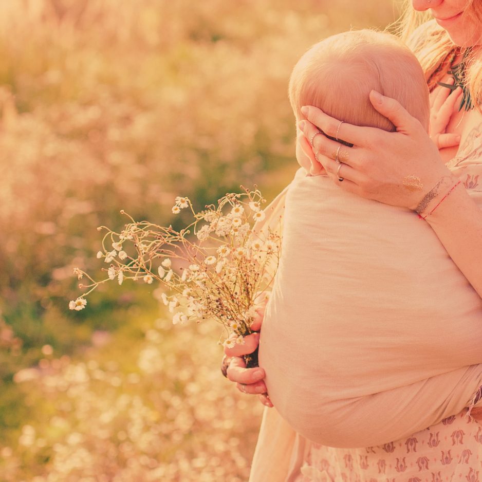 Moeder met baby in een bloemenveld